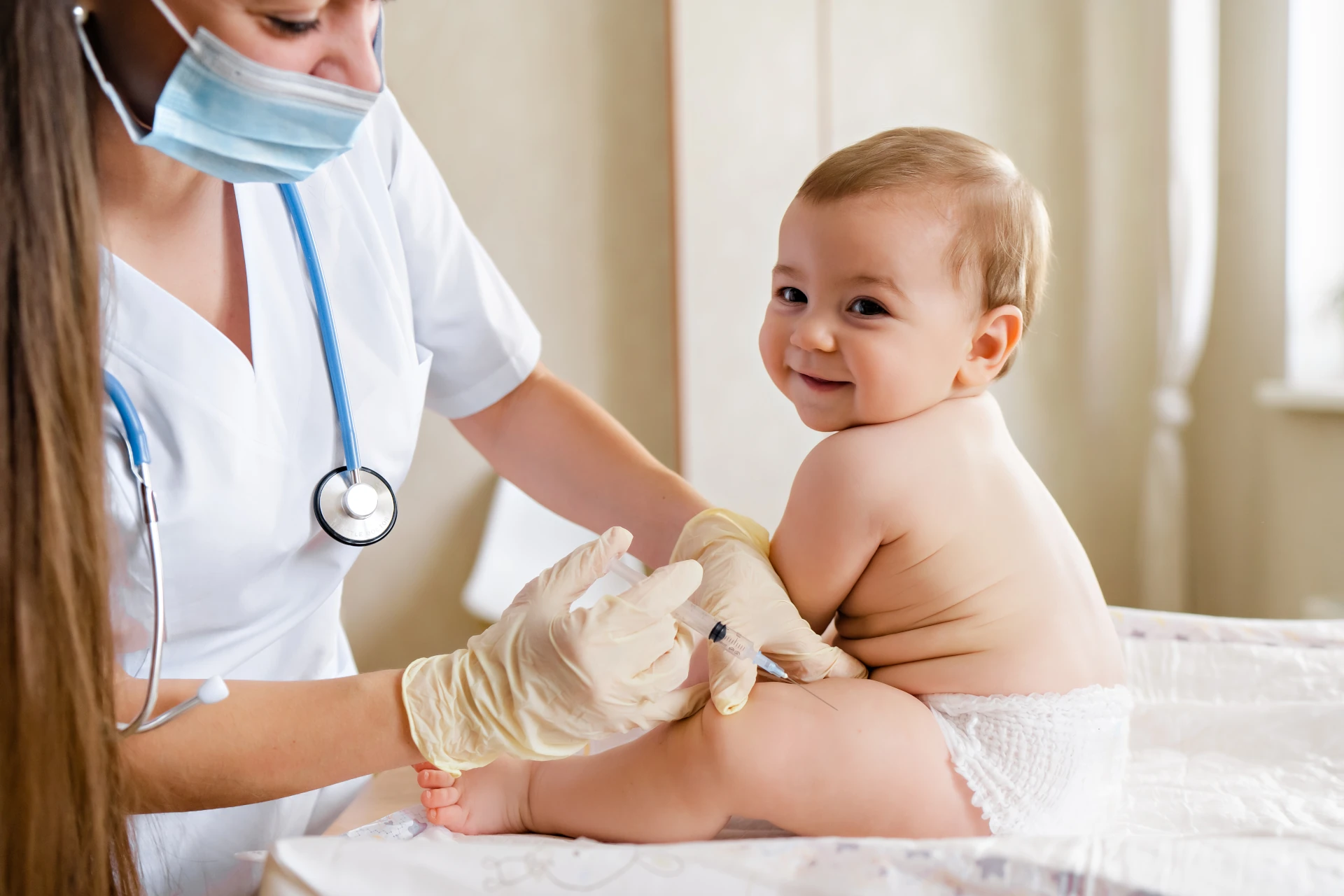 Médica administrando uma vacina em um bebê sorrindo
